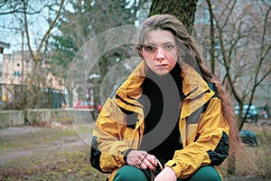 Bad girl bully in yellow coat in the backyard. Outdoor lifestyle portrait