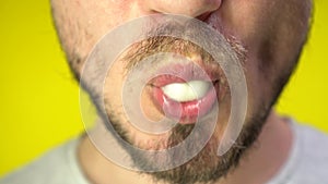 Bad habit concept. Close up of a bearded man`s mouth chewing chewing gum. A man blowing out a bubble of bubble gum