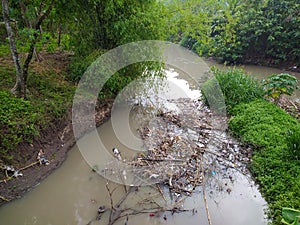 Garbage polluting waterways in river photo