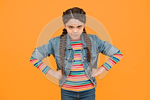In bad humor. Moody little child yellow background. Little baby wear braided hairstyle. Little girl in casual style