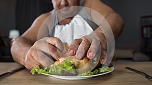 Bad mannered man tearing greasy fried chicken with fingers, fatty food addiction