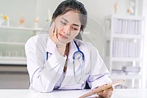 Bad medical results female doctor looking at computer tablet and looking confused in lab coat hospital