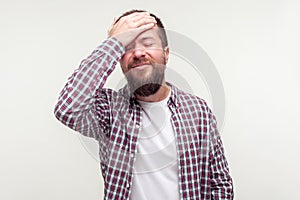 Bad memory. Portrait of forgetful embarrassed bearded man making facepalm gesture, feeling regretful. white background