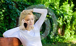 Bad news. Girl blonde tense face talk smartphone green nature background. Woman having mobile phone conversation in park