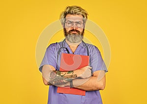 bad news. nurse holding binder and wearing stethoscope. mature bearded male doctor with a folder in uniform standing