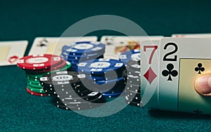 Bad poker gamble or unlucky hand concept with player going all in with 2 and 7 two and seven offsuit also called unsuited,