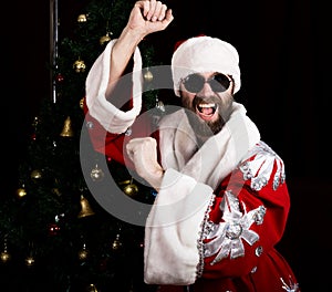 Bad rastoman Santa Claus smiles and fun dancing on the background of Christmas tree