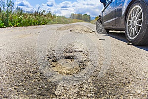 Bad road cracked and damaged. car