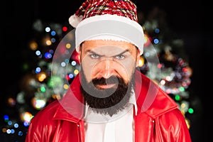 Bad Santa Claus in santa hat. Christmas emotional portrait. Portrait of a brutal mature Santa Claus. Angry man in santa