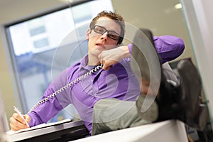 Bad sitting posture - business man in his office on phone