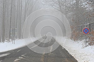 Bad weather driving - foggy hazy country road. Motorway - road traffic. Winter time and snow