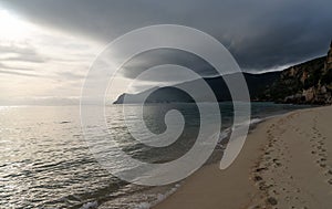 Bad weather moving over mountains onto the ocean and beautiful golden beach photo