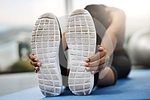 The only bad workout is the one that didnt happen. an attractive young woman sitting with her head down doing stretching