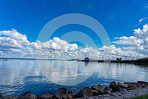 Badacsony pier from the beach at Lake Balaton in Hungary from with blue sky and cloud refletion on the water photo