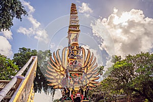 Bade cremation tower with traditional balinese sculptures of demons and flowers on central street in Ubud, Island Bali