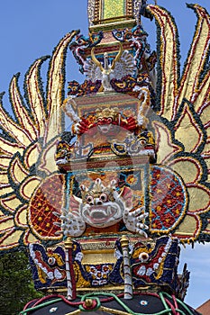 Bade cremation tower with traditional balinese sculptures of demons and flowers on central street in Ubud, Island Bali, Indonesia