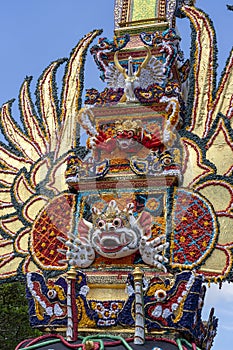 Bade cremation tower with traditional balinese sculptures of demons and flowers on central street in Ubud, Island Bali, Indonesia