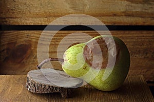 BADLY BLEMISHED PEAR ON A WOODEN SURFACE