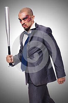 Badly bruised businessman with bat