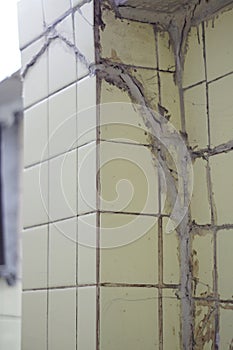 Badly fixed of breaking cracked pillar finishing with light yellow tiles