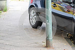 Badly parked car with tire on pavement shows wheel on walkway as traffic violation with penalty for poor driving and parking viola