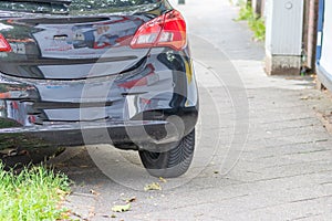 Badly parked car with tire on pavement shows wheel on walkway as traffic violation with penalty for poor driving and parking viola