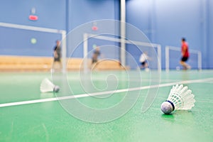 Badminton courts with players and shuttlecocks