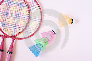 Badminton equipment. Badminton rackets and shuttlecock on pink background. Top view, copy space
