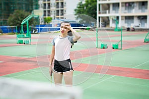 Badminton player wiping sweat on the court