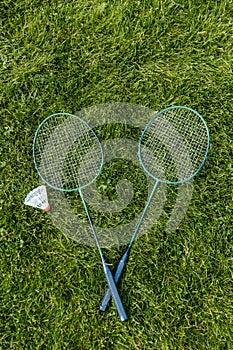 badminton rackets and shuttlecock on grass