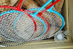 Four badminton rackets in a box with croquet mallets and a shuttlecock