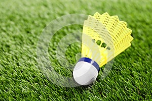 Badminton shuttlecock on green grass outdoors, closeup. Space for text