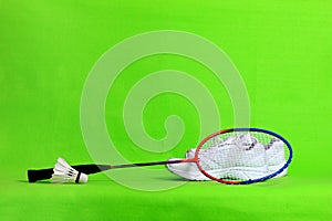 Badminton racket and shuttlecock feathers on light green background with text space.