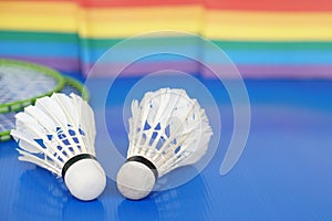 Badminton shuttlecocks on racket. Blurred rainbow colors background.