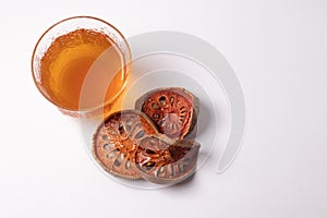 Bael fruit juice and dried quince on a white background