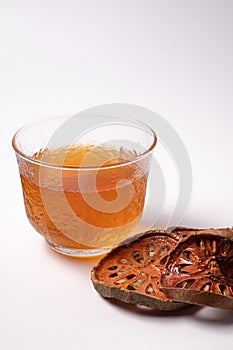 Bael fruit juice and dried quince on a white background