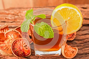 Bael fruit tea - A glass of Bael fruit tea with lemon slices and mint leaf