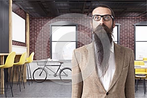 Baffled man in a cafe with brick walls and a bicycle