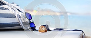 Bag on the beach with sunglasses, shells and towel