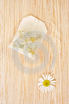 Bag of chamomile tea over wooden background