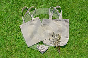 Bag from eco material â€“ unbleached cotton. Shopper feedbag on green grass. Plastic free natural fabric