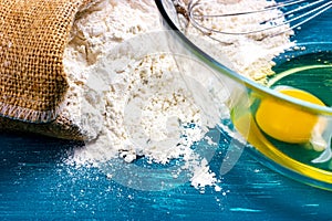 A bag of flour and egg yolks in a glass bowl. Close-up. Ingredients for the test.