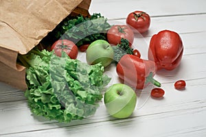 bag of fresh vegetables on a light wooden background .