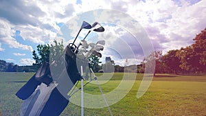 A bag with golf clubs is standing on the golf course