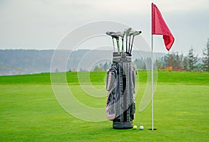 Bag with golf equipment on green pitch