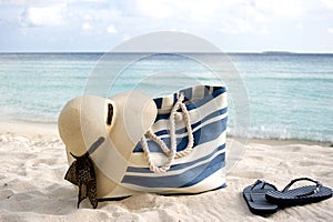 Bag, hat and flip-flops on the beach