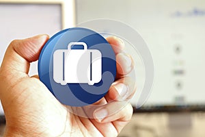 Bag icon blue round button holding by hand infront of workspace background