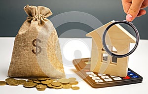 Bag with money and dollar sign and wooden houses. Financing in the country. Investing money in real estate. Saving and