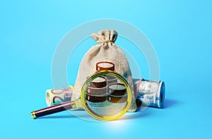 Bag with money and magnifying glass. Investigating capital origins. Deposit or loan terms and conditions. Anti money laundering, photo