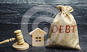 A bag of money with the word Debt and the family standing near the house and gavel. The concept of debt for housing. Mortgage.